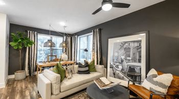 A living room with a white couch, a coffee table, and a large picture on the wall.